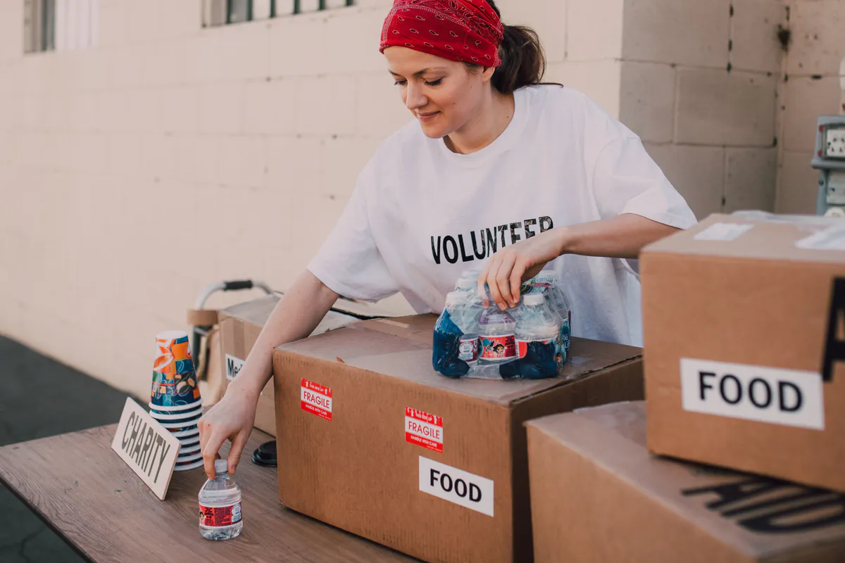 A volunteer sorts boxes of free food and bottled water at a Maine community aid center